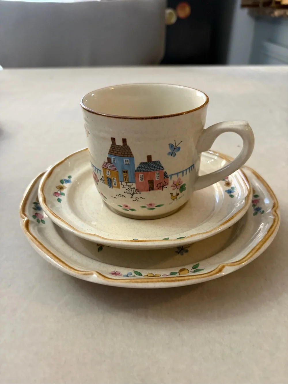 International Cream Ceramic Cup and Saucer Set with Hand-Painted Village Design